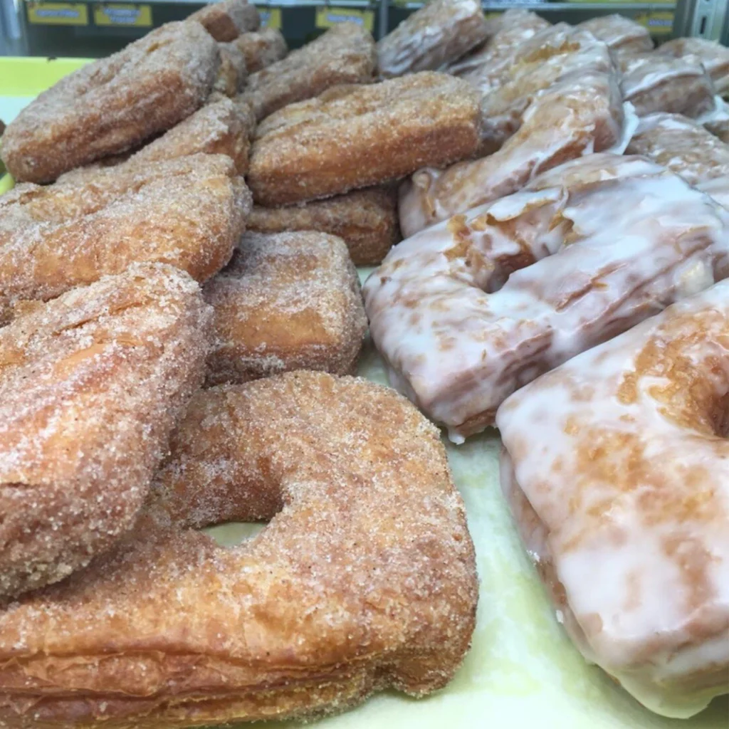 Cronuts on a tray: cinnamon-sugar cronuts on the left, glazed cronuts on the right
